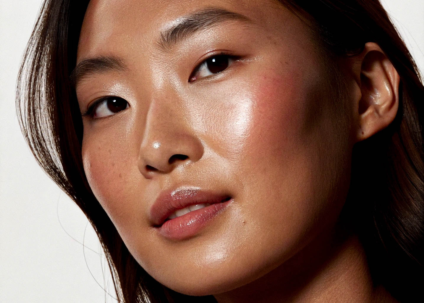 Close-up of a person's face with a neutral expression on a white background