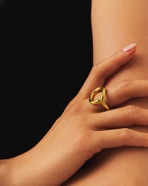 This Auric Ring features a round, rigid design crafted from gold, offering a timeless and durable piece of jewelry. Its solid construction ensures lasting wear, making it an elegant addition to any collection. Ideal for those seeking a classic yet sturdy gold ring with refined simplicity. the woman is wearing it. 1.	18k gold plated jewelry
	2.	gold plated stainless steel jewelry
	3.	tarnish free gold jewelry
	4.	waterproof gold jewelry
	5.	affordable gold jewelry
	6.	non-tarnish gold jewelry
	7.	hypoallerge