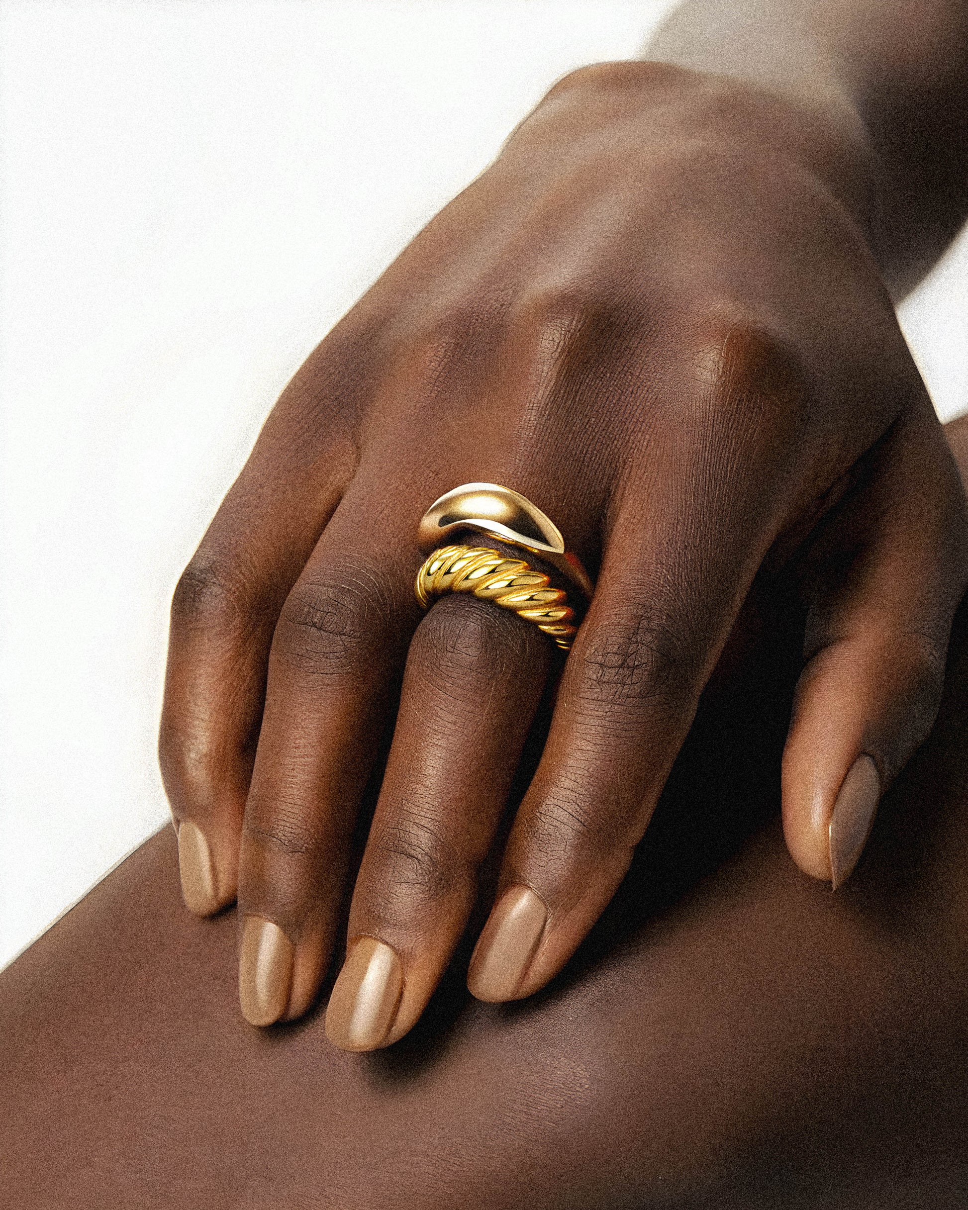 The Cinderlace Ring features a sophisticated gold twist design, perfect for elevating any fashion ensemble. Crafted to combine elegance with contemporary style, this ring adds a refined touch to your look, making it an ideal accessory for both everyday wear and special occasions. Its unique twisted form highlights expert craftsmanship. on a model